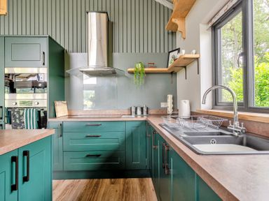 A kitchen with cabinets and a sink at Bwncath in Garthmyl