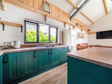A kitchen with a sink and refrigerator at Bwncath in Garthmyl