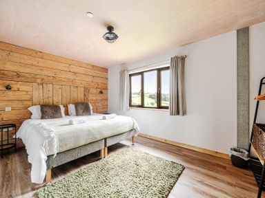 A bedroom with a bed and window at Bwncath in Garthmyl
