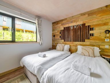 A bedroom with twin beds and a window at Bwncath Garthmyl