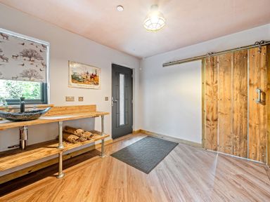 An entrance with a sink and wooden shelf at Bwncath in Garthmyl