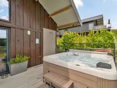 An outdoor area with a hot tub and plants at Bwncath Garthmyl
