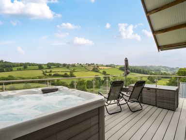 An outdoor area with a hot tub and chairs at Bwncath in Garthmyl
