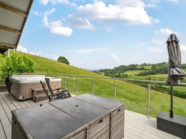 An outdoor area with a hot tub and seating at Bwncath in Garthmyl