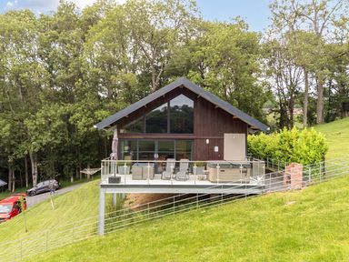 A house with a deck and hot tub at Bwncath in Garthmyl