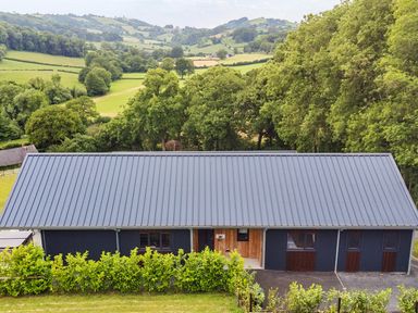 A building with a roof and windows in an outdoor setting at Bwncath in Garthmyl