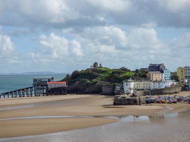 A coastal town with boats on the sandy shore and buildings near the water at 1 St Marys Court in Tenby