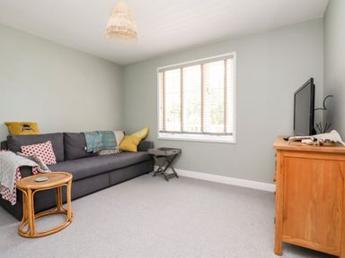 A living room with a dark grey sofa and wooden furniture at Melbecks in Abergele