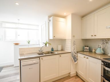A kitchen with white cabinets countertop sink dishwasher kettle and toaster at River Lym Cottage Lyme Regis