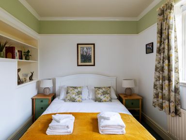 A bedroom with a double bed and folded towels on the blanket at Kail House in Grassington