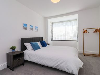 A bedroom with a bed and nightstand at Ty Haul in Rhosneigr