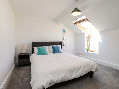 A bedroom with a bed and window at Ty Haul in Rhosneigr