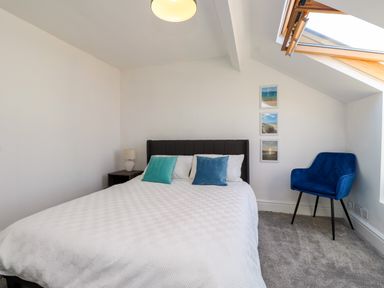 A bedroom with a bed and nightstand at Ty Haul in Rhosneigr