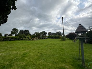 A garden with grass and trees at How Hill Farm Cottage Greystoke