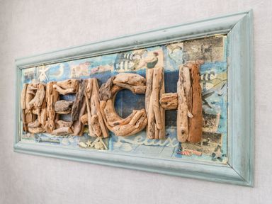 A wall decoration with driftwood letters spelling beach in a blue frame at The Chalet in Coulderton near Egremont Cumbria