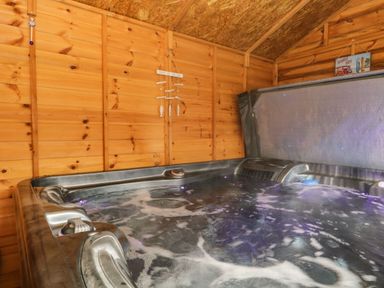 An indoor hot tub with bubbling water inside a wooden room at The Chalet in Coulderton near Egremont Cumbria