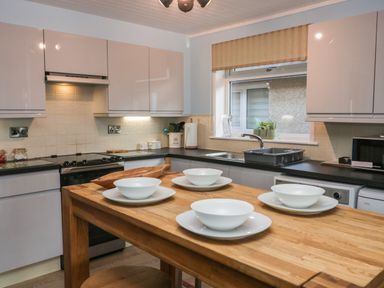 A kitchen with a wooden table set with bowls and plates at The Chalet in Coulderton near Egremont Cumbria