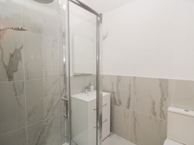 A bathroom with a glass shower enclosure a white sink cabinet with a mirror and a toilet at Swallow Barns in Chipping Sodbury