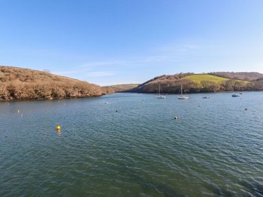 A river or estuary with sailboats and hills covered with trees and grass at Oakenhurst in Golant