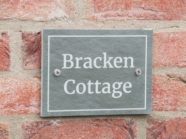 A stone plaque with the words Bracken Cottage fixed to a red brick wall at Bracken Cottage in Pocklington