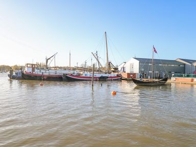 Boats docked near a building by the water at The Penthouse in Woodbridge