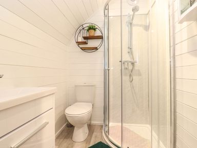 A bathroom with a toilet a shower enclosure and a sink with a cabinet at The Shearer - Crossgate Luxury Glamping in Hartsop near Glenridding