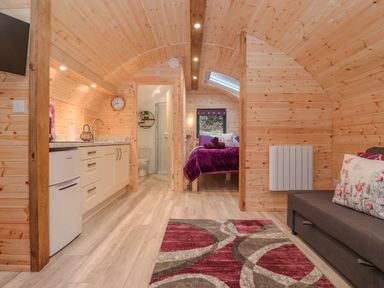 A wooden cabin interior with a kitchenette bathroom and bedroom at Lovies Place - Crossgate Luxury Glamping Hartsop near Glenridding