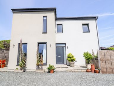 A modern house with windows and plants at Bryn Mor in Benllech