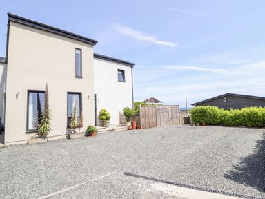 An exterior view of a house with plants and a gravel area at Bryn Mor in Benllech