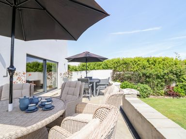 Outdoor seating area with a table and umbrellas at Bryn Mor in Benllech
