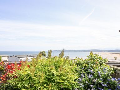 A view of the ocean with green plants at Bryn Mor in Benllech