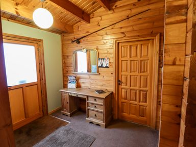 A wooden hallway with a desk and mirror above it at Avocet Lodge in Tattershall Lakes Country Park