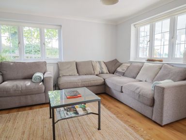 A living room with a sectional sofa and coffee table at Rainbow View in Churchstanton near Churchinford