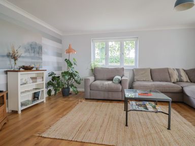 A living room with a couch, coffee table, and plants at Rainbow View, Churchstanton near Churchinford