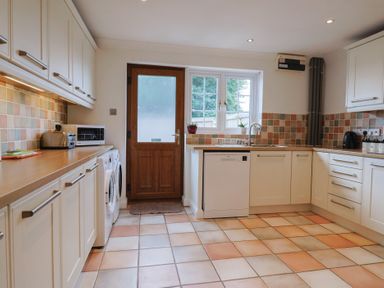 A kitchen featuring appliances and a door at Rainbow View in Churchstanton near Churchinford