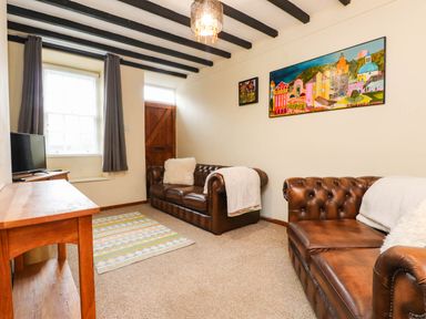 A living room with a TV and sofas at 11- 13 High Street