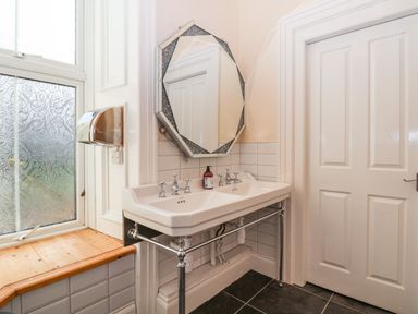A bathroom with a double sink vanity mirror window and door at The Lloyd George in Bontnewydd Gwynedd