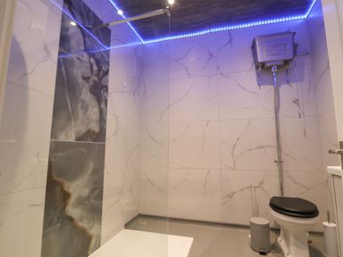 A bathroom with a walk-in shower and a high-level toilet at The Lloyd George in Bontnewydd Gwynedd