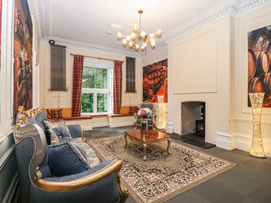 A sitting room with upholstered chairs a coffee table and a fireplace at The Lloyd George in Bontnewydd Gwynedd