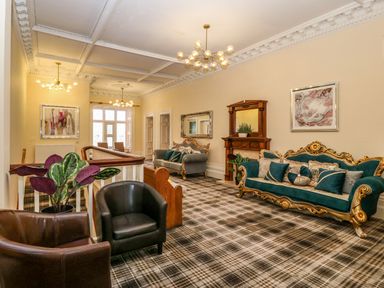 A sitting area with sofas armchairs a plant and fireplace in a room at The Lloyd George in Bontnewydd Gwynedd
