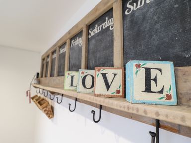 Wooden shelf with letter blocks spelling love below a weekly chalkboard calendar at 3 Ivy Court in Dolgellau