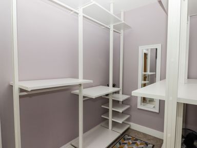 A walk-in closet with white shelving and a wall mirror at Ty Marlyn in Crofty