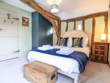A bedroom with a bed pillows bedside table and wooden chest at The Bridewell in Woodbridge