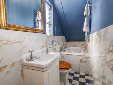 A bathroom with a sink mirror toilet bathtub and window at The Bridewell in Woodbridge