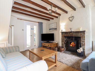 A living room with a fireplace and sofa at Riverside Cottage in Beddgelert