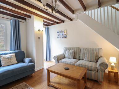 A living room with sofas and a coffee table at Riverside Cottage in Beddgelert