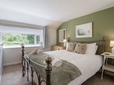 A bedroom with a bed and window at Riverside Cottage in Beddgelert