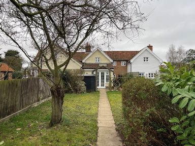 A garden path leading to a cottage with multiple sections and a tiled roof at 2 Mosses Cottage in Friston