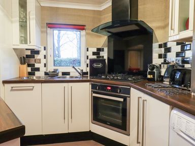 A kitchen with a gas stove oven dishwasher sink and countertop appliances at Washburn Lodge in Fewston near Darley