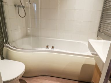 A bathroom with a bathtub shower combination a toilet and a sink at Washburn Lodge in Fewston near Darley